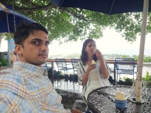 a couple enjoying a relaxed moment at a seaside cafe under tree shade