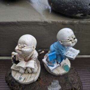 two adorable baby monk statues placed outdoors at a temple on sanbangsan